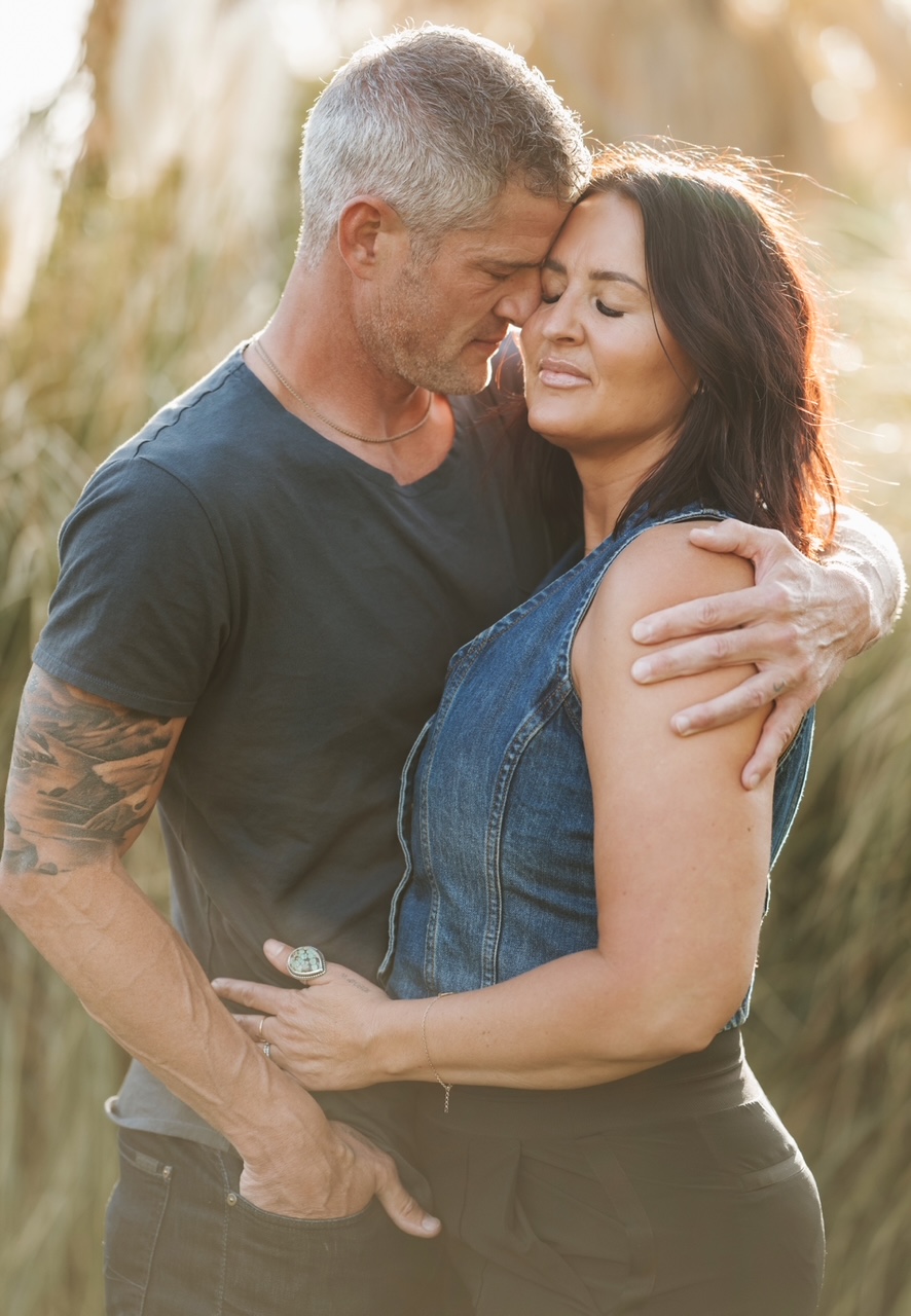 A couple embracing closely in golden evening light
