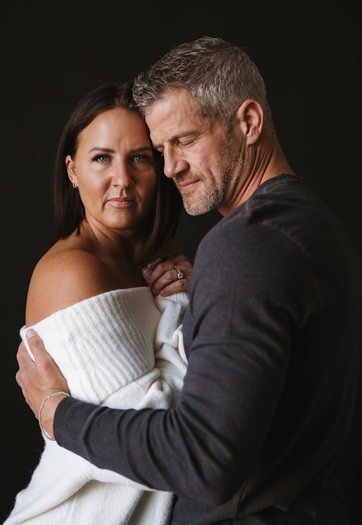 Darci and Brandon Burke embracing in an intimate studio portrait